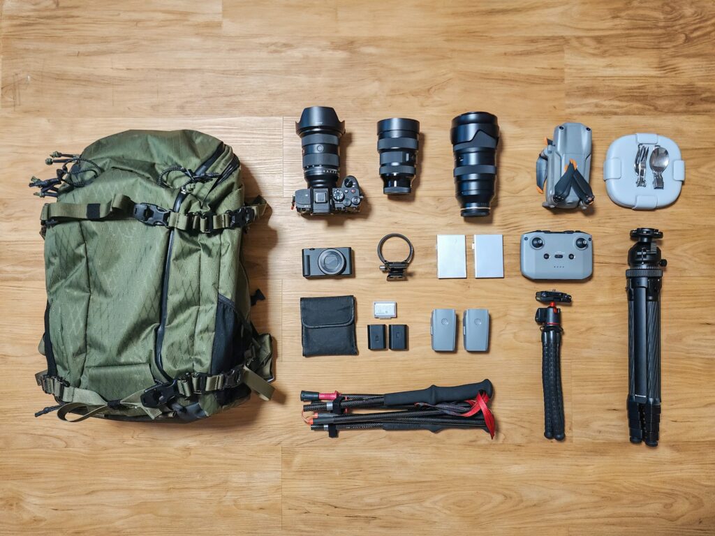 Set of photographer gear with mirrorless camera, lens, tripod, drone and backpack